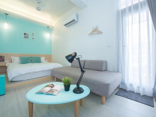 a living room with a bed and a lamp on a table at 極簡旅行民宿 Simple Travel B&B in Wujie