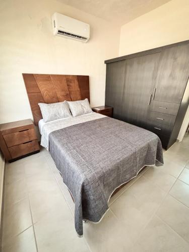 a bedroom with a large bed with a wooden headboard at Blue Sea Vallarta - Relax, Explore and Enjoy! in Los Algodones