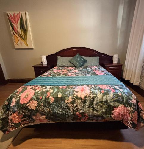 ein Schlafzimmer mit einem Bett mit einer geblümten Tagesdecke in der Unterkunft Naracoorte Central Accommodation in Naracoorte