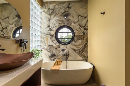 a bathroom with a large tub and a sink at Bale Marva, Gianyar - Modern Tropical Hideaway near Ubud & Bali Safari Park in Lebih
