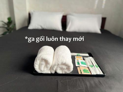 a tray with towels and toothbrushes on a bed at ấm iu Hotel in Ho Chi Minh City
