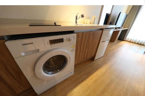a washing machine in a kitchen with a counter at Hotel Rest Seogwipo in Seogwipo