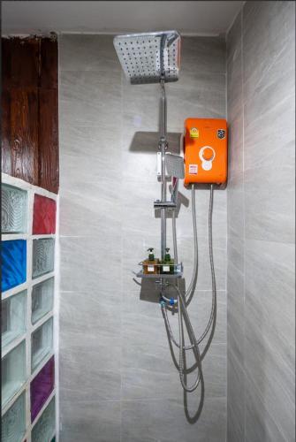 a shower in a bathroom with an orange machine at Maya guest house@coffee in Ko Chang