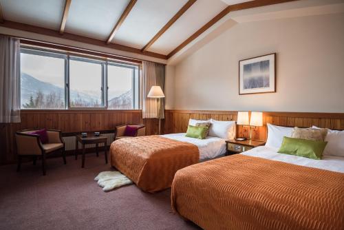 Postel nebo postele na pokoji v ubytování Okushiga Kogen Hotel