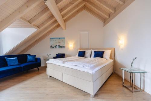 a bedroom with a large bed and a blue couch at Rössli Hurden in Hurden