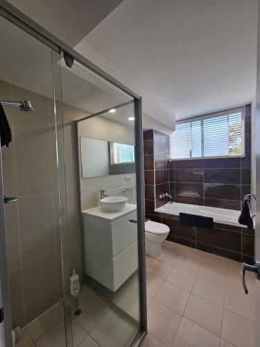 a bathroom with a sink and a toilet and a shower at South Cronulla Liandys in Cronulla