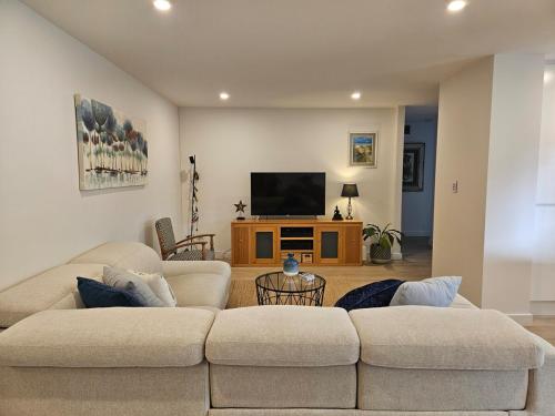 a living room with two couches and a flat screen tv at South Cronulla Liandys in Cronulla