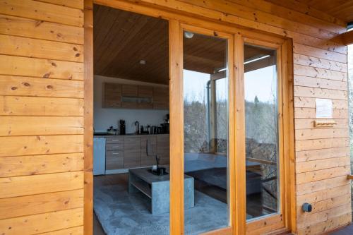 a large glass doorway to a kitchen in a cabin at Nature&Chill Treehouses in Sopron