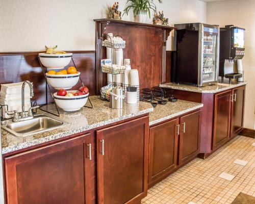 a kitchen with wooden cabinets and a sink with fruit on the counter at Quality Inn Clarion in Clarion