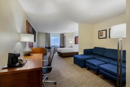 een hotelkamer met een blauwe bank en een bed bij Comfort Suites Johnson Creek Conference Center in Johnson Creek
