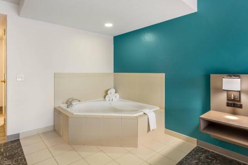 Un baño con bañera y una pared azul. en Comfort Inn & Suites Dover, en Dover