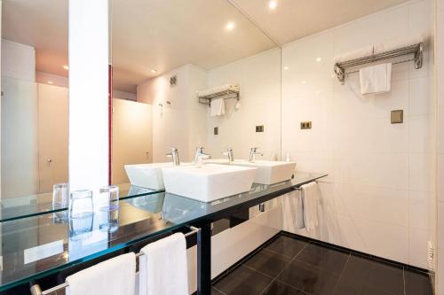 a bathroom with two sinks and a mirror at Radisson Blu Acqua Hotel & Spa Concon in Concón