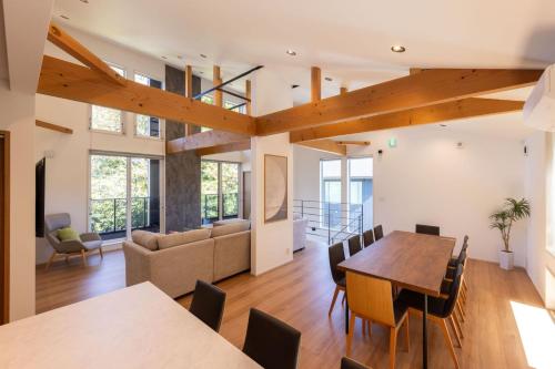 a dining room and living room with a table and chairs at Hakuba Mitsuki Chalet in Hakuba