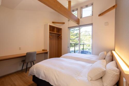 a bedroom with two beds and a window at Hakuba Mitsuki Chalet in Hakuba
