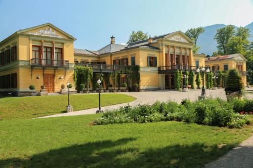 a large yellow house with a garden in front of it at Villa Leni - Premium Apartments in Bad Ischl