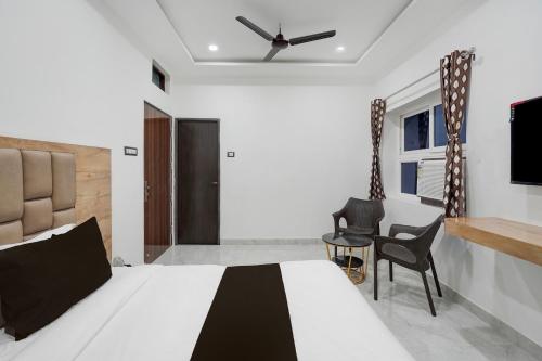 バラナシにあるSuper Collection O Banaras Railway Junction Formerly Varanasi Suitesのベッドとテレビと椅子のある寝室