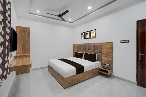 バラナシにあるSuper Collection O Banaras Railway Junction Formerly Varanasi Suitesのベッドと天井扇風機のある寝室