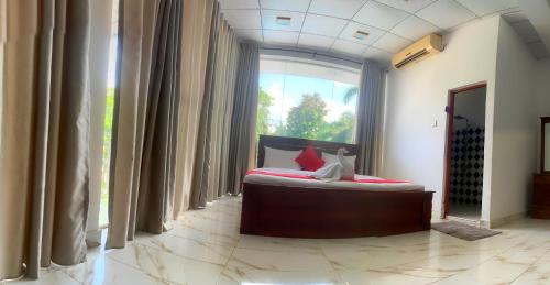 Un dormitorio con una cama y una ventana grande en Meshendra Garden Hotel by Fairway Hotels, en Katunayake