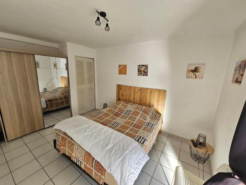 ein Schlafzimmer mit einem Bett und einem Spiegel in der Unterkunft T2 CARRY LE ROUET CENTRE VILLE PROCHE DE LA MER in Carry-le-Rouet