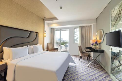 a hotel room with a bed and a television at Fairview Hotel by ARTOTEL in Jakarta