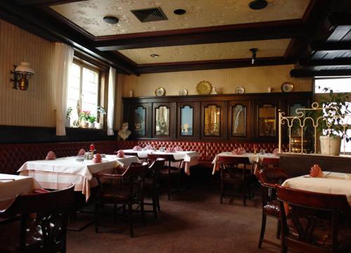 a dining room with tables and chairs with white table cloth at Hotel Filoxenia in Stuttgart