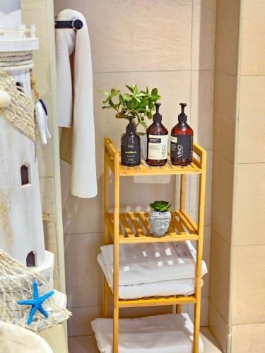 a bathroom with a shelf with towels and a plant at Chic Yas Stay, F1, Ferrari, Sea World Yas Island in Abu Dhabi