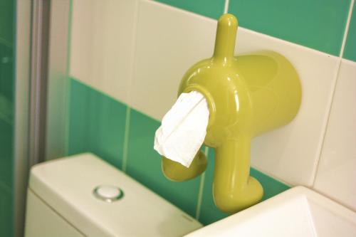 a yellow toilet paper holder on the wall of a bathroom at 日吉民宿 in Luodong