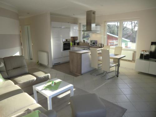 eine Küche und ein Wohnzimmer mit einem Sofa und einem Tisch in der Unterkunft Ferienwohnung Marquardt mit Wallbox in Boltenhagen