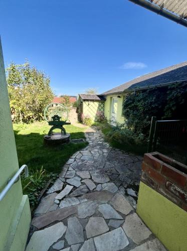 a garden with a stone walkway next to a house at les chaussons d'arlequine in Dompierre-sur-Besbre