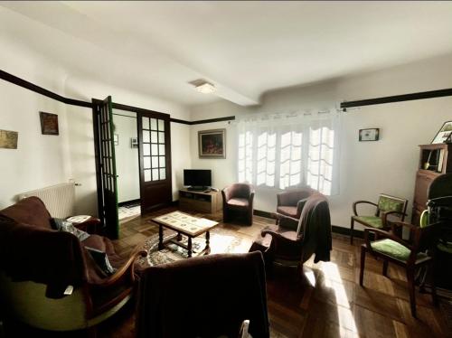 a living room with couches chairs and a tv at les chaussons d'arlequine in Dompierre-sur-Besbre