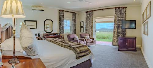 a bedroom with a bed and a tv and a couch at RiverBend Lodge in Addo