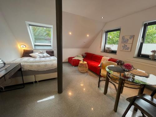 a living room with a red couch and a bed at Ferienhaus am Dürrbachtal in Unterleinleiter