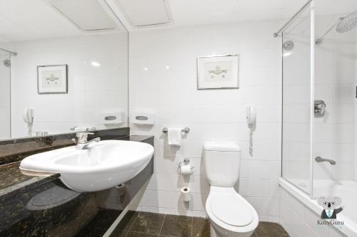 KozyGuru | Parramatta Studio Steps to Shops, Cafés في سيدني: حمام أبيض مع حوض ومرحاض