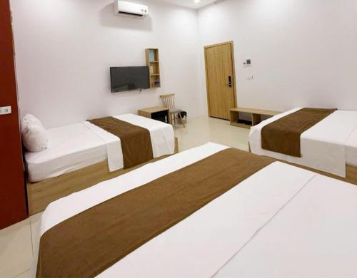a hotel room with two beds and a flat screen tv at Green Hotel Cao Bằng in Cao Bằng