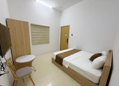 a bedroom with a bed and a table and a chair at Green Hotel Cao Bằng in Cao Bằng