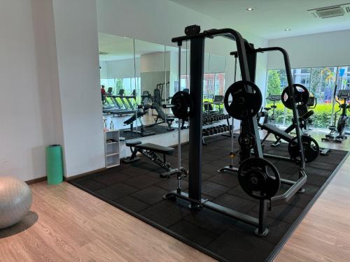 einen Fitnessraum mit mehreren Laufbändern und einem Spiegel in der Unterkunft Family-Friendly 3BR Stay I MIRAI Residence, Kajang 2 in Kajang