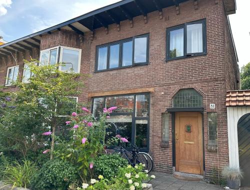a brick house with a bike parked in front of it at Stylish * Sunny * Cosy House in Heemstede