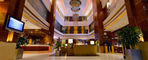 a lobby of a hotel with tables and a tv at Park Lane Hotel Lahore in Lahore