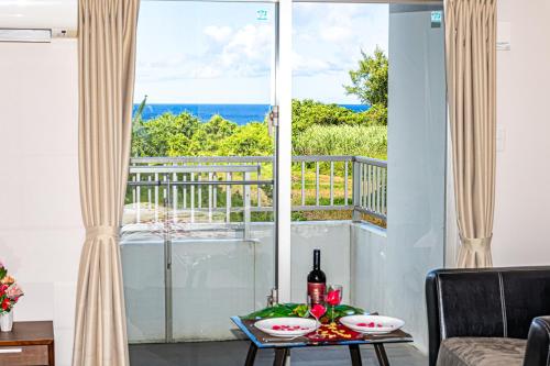 een kamer met een tafel en uitzicht op de oceaan bij 真栄田岬グランブルー 104 in Onna