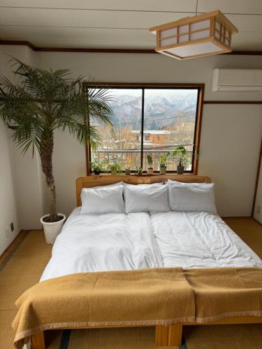 a bedroom with a large bed with a palm tree at Butter Hotel in Otari