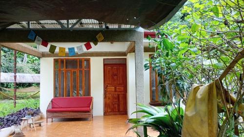 a house with a red chair on a porch at Zen Mountain Escape 3BR Getaway near Chirripó in Rivas