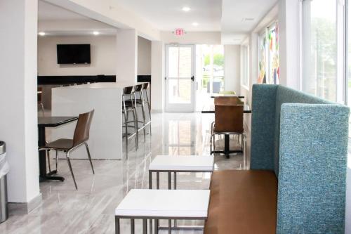 a living room with a couch and chairs and a bar at Clarion Pointe Bettendorf - Quad Cities in Bettendorf