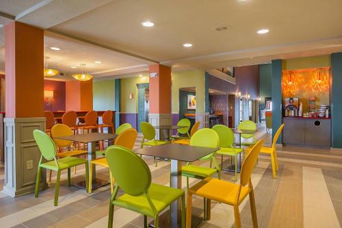 a restaurant with tables and chairs in a cafeteria at Clarion Inn & Suites Evansville Eastland Area in Evansville