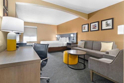a hotel room with a bed and a living room at Comfort Inn & Suites Kansas City - Northeast in Kansas City