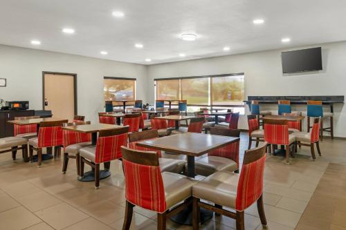 a restaurant with tables and chairs and a flat screen tv at Comfort Inn & Suites Kansas City - Northeast in Kansas City