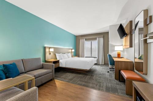 a hotel room with a bed and a couch at Comfort Suites Gothenburg South in Gothenburg