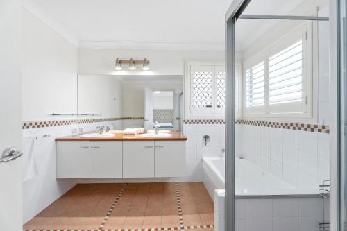 a white bathroom with a sink and a shower at Entire home in Southport Parade Southport in Gold Coast
