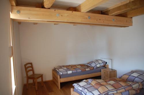 a bedroom with two bunk beds and a chair at Carles Scheunenhof in Zweiflingen