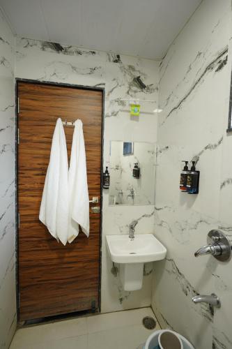 Un baño con lavabo y puerta de madera. en Hotel Deol's Paradise, en Indore