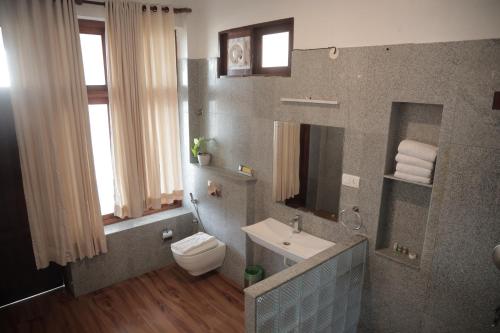 een badkamer met toilet en wastafel bij By The Bay Kovalam in Trivandrum